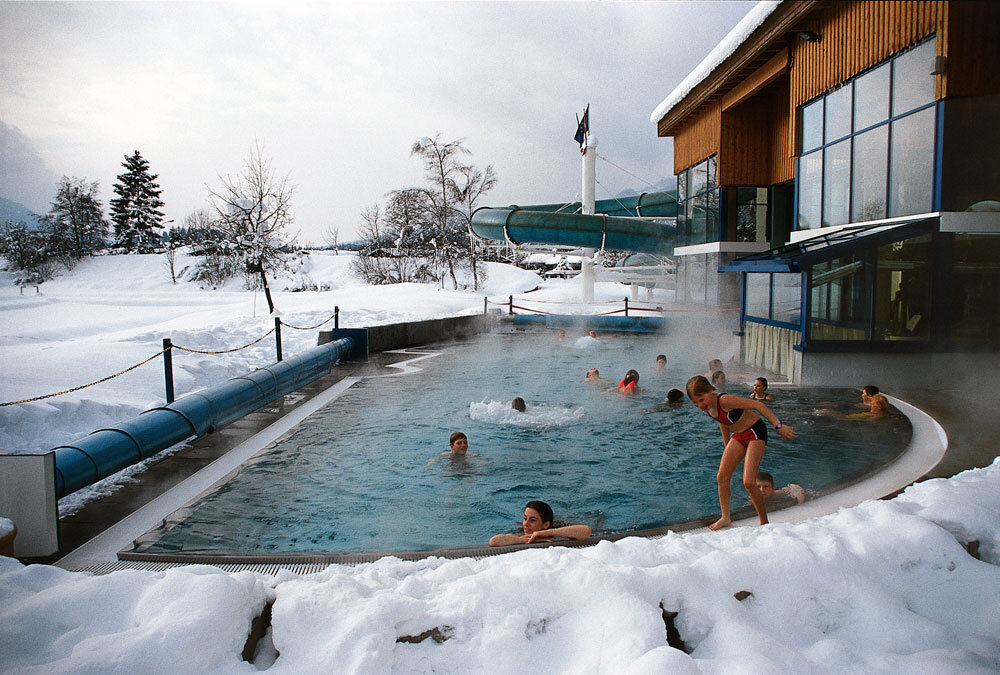 Dampfendes Außenbecken der Badewelt im Winter, ringsum Schnee